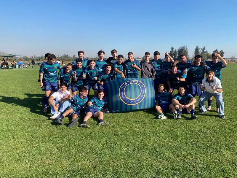 Plantel de Old Brads con la bandera del club en la Liga COF